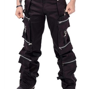 May include: Black cargo pants with multiple zippered pockets and straps. The pants have a slim fit and are made of a durable fabric.