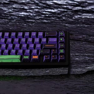 May include: A black mechanical keyboard with purple and green keycaps. The keyboard has a green and black spacebar and a row of orange keys. The keyboard has the words "EMERGENCY" and "A-01" printed on two of the keys.