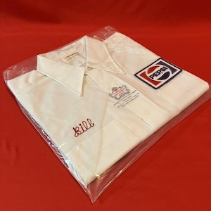 May include: White collared shirt with a Pepsi logo patch and embroidered name "Bill". The shirt is folded and sealed in a clear plastic bag. Additional logo and text are visible on the shirt.