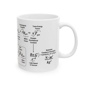 May include: White ceramic mug with a black graphic of Einstein's field equations, including the cosmological constant, stress-energy tensor, Einstein gravitational constant, and Newtonian constant of gravitation. The equations are written in a scientific style with Greek letters and mathematical symbols.