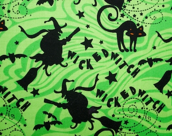 May include: Green fabric with a repeating pattern of black silhouettes of witches flying on broomsticks, black cats, and bats. The fabric has the words "Wicked Witch" repeated throughout the pattern.
