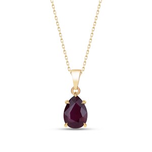 May include: A gold-colored necklace with a pear-shaped, deep red gemstone pendant. The pendant is suspended from a delicate chain, creating an elegant and classic jewelry piece. The gemstone is faceted, catching the light and adding sparkle.