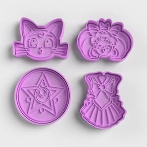 May include: A set of four light purple plastic cookie cutters. The shapes include a cat face with a crescent moon, a character head with twin buns, a circular star emblem with a crescent moon center, and a pleated skirt with a bow detail.
