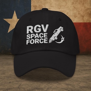 May include: Black baseball cap with white embroidered text that reads "RGV SPACE FORCE" and a white embroidered image of a pickup truck launching into space.