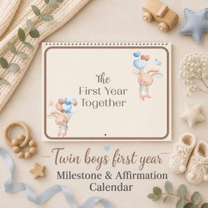 Puede incluir: Un calendario de espiral titulado The First Year Together, con ilustraciones de dos conejos marrones sosteniendo globos azules y beige. Debajo del calendario, el texto dice Twin boys first year Milestone & Affirmation Calendar.