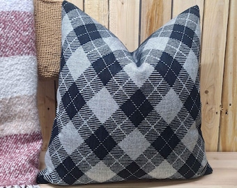 May include: A black and white diamond patterned throw pillow. The pillow is made of a soft, textured fabric.