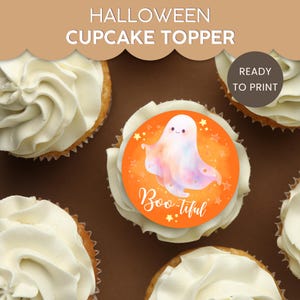 May include: A Halloween cupcake with white frosting and a round orange topper. The topper features a cute ghost illustration with the text "Boo-tiful". The words "Halloween Cupcake Topper" are at the top of the image.