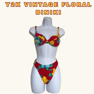 May include: A red, yellow, and green floral print bikini. The bikini top is a push-up style with adjustable straps. The bikini bottom is a high-cut style.