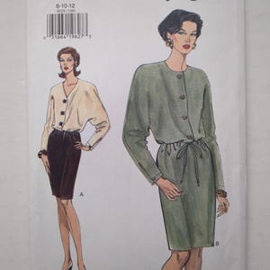 Könnte beinhalten: Ein Very Easy Very Vogue Schnittmusterumschlag 9029 für die Größen 8-10-12. Die Vorderseite zeigt zwei Illustrationen: ein cremefarbenes Oberteil mit Knöpfen und dunklem Rock sowie ein salbeigrünes Langarmkleid mit Kordelzug in der Taille.