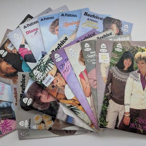 May include: A collection of vintage Patons and Beehive knitting pattern booklets arranged in a fan shape. The booklets feature various cover photographs of people wearing knitted garments, with printed text including titles and prices in dollars.