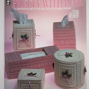 Peut inclure: Ensemble de boîtes à mouchoirs en plastique et une petite boîte, dans des tons de rose et de blanc. Le texte "PRETTY WITH PINK" est affiché en haut de l'image. Les articles sont décorés d'éléments floraux.