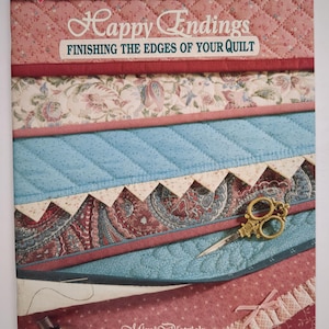 May include: A quilting book titled "Happy Endings" with the subtitle "Finishing the Edges of Your Quilt." The cover displays layered fabric samples in pink, blue, and patterned designs. A pair of gold scissors rests on the fabric.