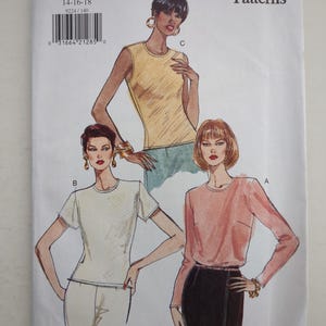 Può includere: Una busta per cartamodello Vogue Patterns numero 9224 per le taglie 14-16-18. La parte anteriore presenta illustrazioni di tre top: un top giallo senza maniche, un top bianco a maniche corte e un top rosa a maniche lunghe, abbinati a gonne o pantaloni.