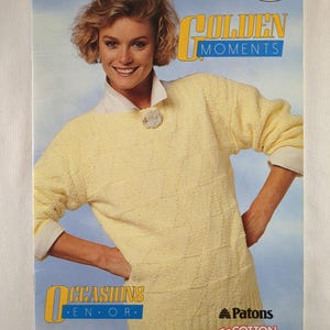 Könnte beinhalten: Ein Vintage-Magazin-Cover mit einer Frau in einem hellgelben Pullover. Das Cover zeigt den Text "GOLDEN MOMENTS" und "OCCASIONS EN OR". Das Patons-Logo ist sichtbar, zusammen mit dem Text "COTTON Sahara".