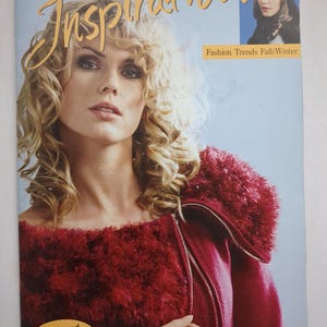 May include: A magazine cover featuring a woman with blonde curly hair wearing a red sweater with a fluffy collar. The word "Inspiration" is in large gold letters. Text reads "Fashion Trends Fall/Winter" and "+ chic and quick accessories."