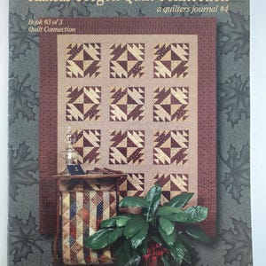 Könnte beinhalten: Das Cover des Quilting-Journals "Kansas Oregon Quilt Connection" zeigt ein Steppmuster in Beige und Burgunderrot. Der Text enthält "Book #3 of 3" und "Kansas Troubles Quilters". Es ist das Quilter-Journal #4.