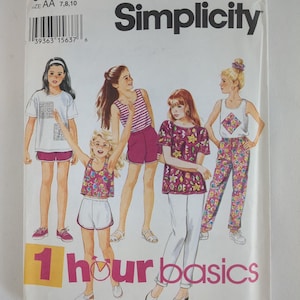 Może przedstawiać: Wzór szycia Simplicity z ilustracjami strojów dla dziewczynek. Okładka przedstawia dziewczynki w szortach, spodniach i topach. Tekst "1 hour basics" jest wyświetlany w kolorze różowym i żółtym.
