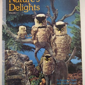 May include: A book cover for "Nature's Delights, Volume 1" showing a forest scene at night. The cover art features four owl figures on a tree branch. The owls have large yellow eyes and brown and beige feathers.