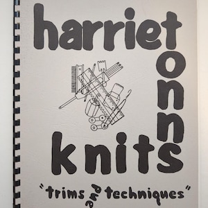 Puede incluir: Un libro de instrucciones con encuadernación en espiral y cubierta gris claro con texto negro que dice Harriet Knits Trims and Techniques. El centro de la cubierta muestra una ilustración de línea negra de varias herramientas de tejer y coser.