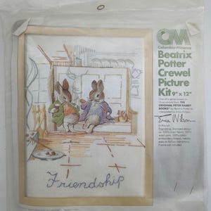 Peut inclure: Un kit de broderie de Beatrix Potter, 23 cm x 30 cm, avec une scène brodée de deux lapins. Le mot "Friendship" est brodé en dessous. Le kit comprend un motif imprimé sur tissu de lin, de la laine et du fil à broder.