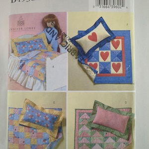 May include: A Butterick sewing pattern for doll bedding. The pattern features various quilt and pillow designs, including heart and floral patterns. The package includes images of the finished products, showcasing different color schemes and styles.