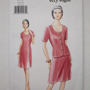 Könnte beinhalten: Ein Very Easy Very Vogue Schnittmusterumschlag 9220 für die Größen 6-8-10. Die Abbildung zeigt ein zweiteiliges Outfit in Altrosa, bestehend aus einer kurzärmeligen Jacke mit vier Knöpfen und einem passenden knielangen Rock sowie einem Kleid.