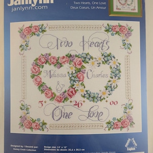 May include: A cross-stitch kit with a design of two floral hearts and the words "Two Hearts, One Love." The design size is 35.6 cm x 30.5 cm. The kit includes fabric, floss, beads, needles, and instructions. The kit is from Janlynn.
