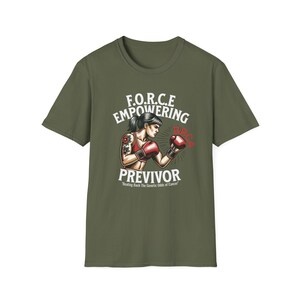 May include: Olive green t-shirt featuring a graphic of a woman in boxing gloves with a tattoo on her arm. The text reads "F.O.R.C.E Empowering Previor" with the tagline "Beating Back The Genetic Odds of Cancer".