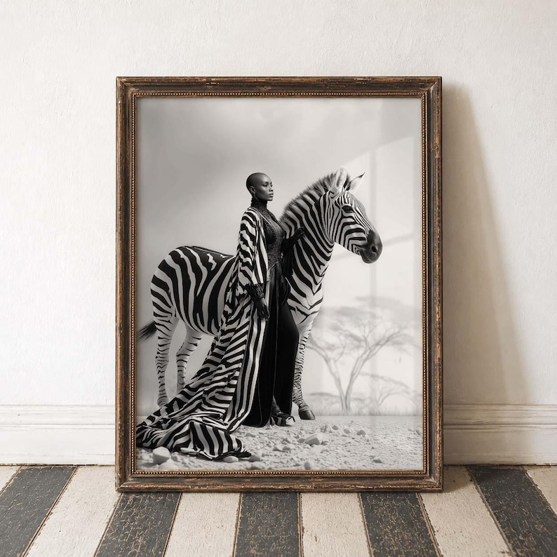 May include: Monochrome framed print showing a person in a striped robe posing with a zebra. The artwork has a vintage feel, with a neutral backdrop and a wooden frame, suitable for home decor.