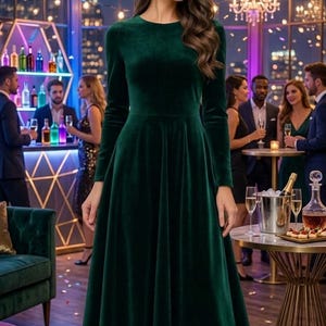 May include: A long-sleeved, knee-length dress in a deep emerald green velvet fabric. The garment features a round neckline, a fitted bodice, and a flared, pleated skirt that falls below the knees. The dress is paired with simple gold-toned strappy heels.