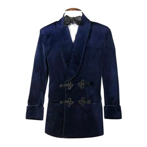 May include: A navy blue velvet tuxedo jacket with a shawl collar and black frog closures. The jacket has a double-breasted design and features a black and white polka dot bow tie.
