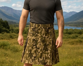 Könnte beinhalten: Eine Person trägt ein dunkelgraues T-Shirt und einen Kilt mit Tarnmuster in Grün- und Brauntönen. Die Person trägt auch braune Stiefel. Der Hintergrund zeigt eine Landschaft mit Bergen und einem See.