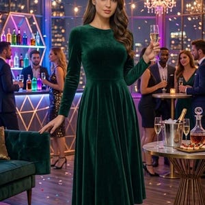 May include: A long-sleeved, knee-length dress made of dark green velvet fabric. The dress features a round neckline, a fitted bodice, and a flared skirt that falls below the knees. The garment is constructed with a smooth, solid-colored velvet material.