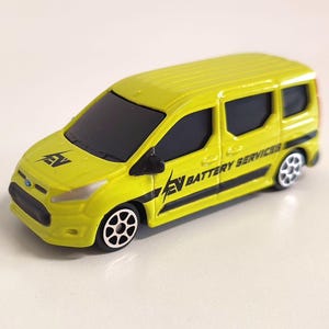 Puede incluir: Una camioneta de juguete amarilla con detalles negros y las palabras "EV Battery Services" en el lateral.