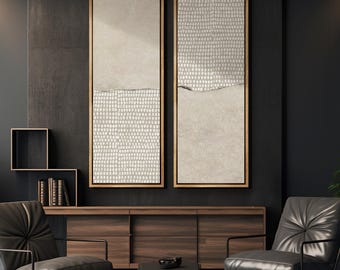 May include: Two abstract paintings in beige and white with a textured pattern. The paintings are framed in a light wood frame and are hanging on a dark wall. The paintings are above a dark wood cabinet with two chairs in front of them.