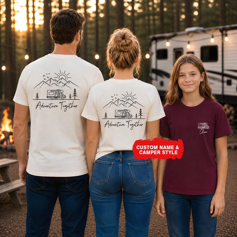 May include: Three people wearing matching t-shirts with a camping theme. The shirts are cream and burgundy. The cream shirts have a mountain, sun, camper, and tree design with the words "Adventure Together." The burgundy shirt has a camper design.