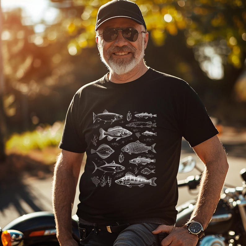 Puede incluir: Camiseta negra con una ilustraci&oacute;n blanca detallada de varias especies de peces. El dise&ntilde;o incluye diferentes tipos de peces, algas y plantas acu&aacute;ticas. La camiseta es de estilo cuello redondo cl&aacute;sico.