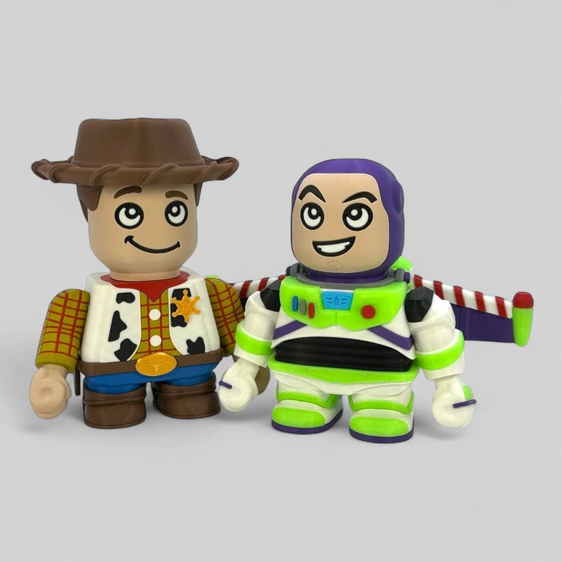 May include: Two toy figurines of Woody and Buzz Lightyear from the film Toy Story. Woody wears a brown hat, vest, and sheriff's badge. Buzz Lightyear has a purple helmet, green and white spacesuit, and wings.