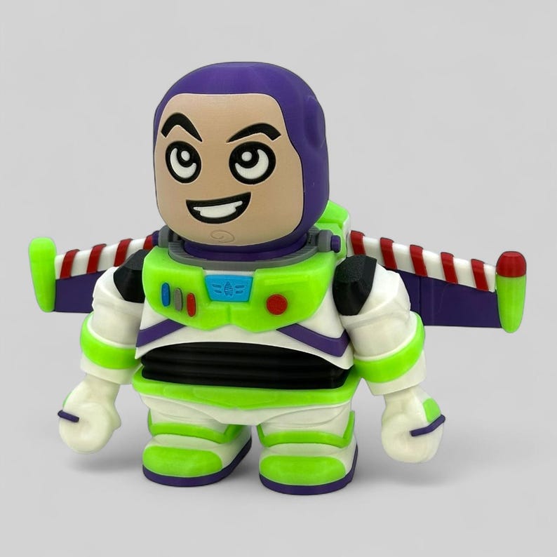 May include: A stylized Buzz Lightyear figurine. The figure has a purple helmet, a smiling face, and a green and white spacesuit. The wings are purple with red and white stripes. The toy is a collectible item.