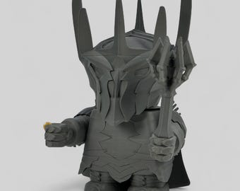 May include: A gray figurine of a character from a fantasy series, holding a staff and a small gold ring. The figure has a detailed helmet and armor, with a black cape. The figurine is a collectible item.