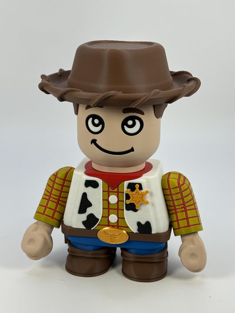 May include: A toy figure of a cowboy with a brown hat, a red neckerchief, and a yellow sheriff's badge. The figure has a white vest with black cow spots, a yellow plaid shirt, and blue jeans. The figure is a collectible toy.