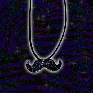 May include: A black mustache pendant necklace with a starry design. The pendant is suspended from a black cord against a purple and black zebra print background with sparkling stars.