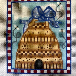 May include: A brown and tan beehive with a blue bow on top. The beehive is surrounded by a red and white striped border.