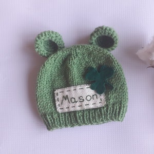 Può includere: Cappellino di lana verde per neonato con un trifoglio e il nome "Mason" ricamato.