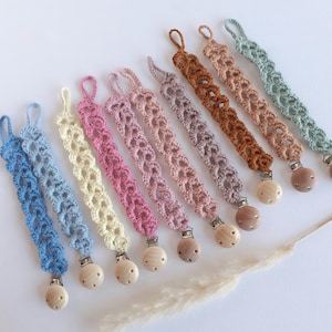 May include: A set of ten crocheted dummy clips in various pastel colours with wooden beads. The clips are made with a delicate, lacy pattern and are perfect for attaching to a dummy or teether.