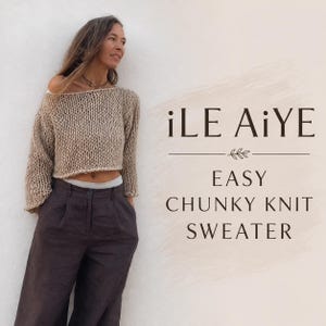 Könnte beinhalten: Ein beigefarbener Grobstrickpullover mit weitem U-Boot-Ausschnitt und langen Ärmeln, kombiniert mit einer dunkelbraunen Hose. Der Text iLE AiYE EASY CHUNKY KNIT SWEATER steht rechts in einer dunkelbraunen Serifenschrift.