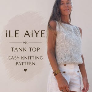 Może przedstawiać: Bezrękawnik z grubego dzianinowego splotu w jasnym kolorze o teksturowanym ściegu. Obraz zawiera tekst iLE AiYE TANK TOP EASY KNITTING PATTERN. Ubiór zestawiono z białymi szortami z brązowymi guzikami wzdłuż przedniej linii talii.