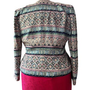 Peut inclure: Une veste &agrave; motifs au design vibrant. La veste pr&eacute;sente un m&eacute;lange de couleurs, dont le marine, le rose et le sarcelle, dispos&eacute;es en motifs circulaires et ray&eacute;s r&eacute;p&eacute;titifs. La veste a des manches longues et une coupe ajust&eacute;e, avec un bas rouge.