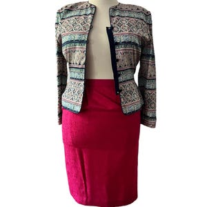 Peut inclure: Ensemble deux pi&egrave;ces compos&eacute; d'une veste &agrave; motifs et d'une jupe unie rouge vif. La veste pr&eacute;sente un motif d&eacute;taill&eacute; dans les tons de bleu, rose et beige. La veste est bord&eacute;e d'un liser&eacute; bleu marine.