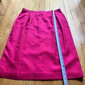 Peut inclure: Une jupe rose vif avec une surface textur&eacute;e. Un ruban &agrave; mesurer est pos&eacute; sur la jupe. La jupe mesure environ 76 cm de long.